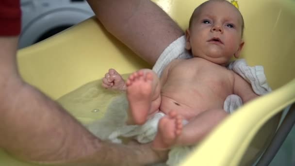 Мужчина нежно держит ребенка в ванной — стоковое видео