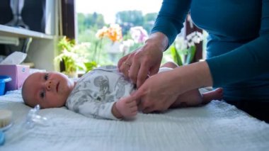 Anne bebeğini sevgiyle ve dikkatli bir şekilde değiştirme