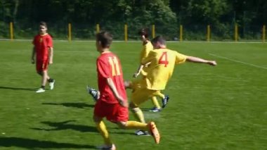 Yeşil sahada futbol oynayan çocuklar