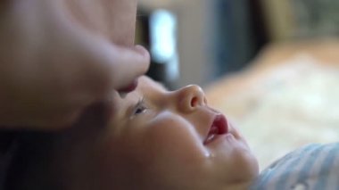 Anne meme ve bebeğin göz içine bir damla süt bırakarak