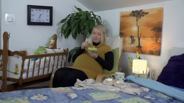 Mujer embarazada sentada en un sillón — Vídeos de Stock