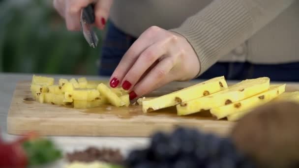 Женщина режет ананас — стоковое видео