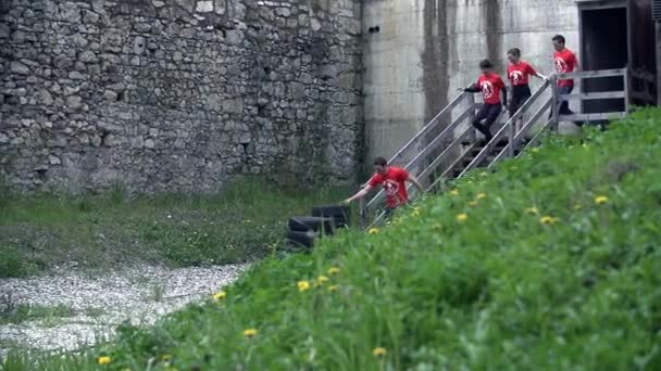 Equipo de deportes en juegos de gladiador corriendo y recogiendo neumáticos — Vídeo de stock