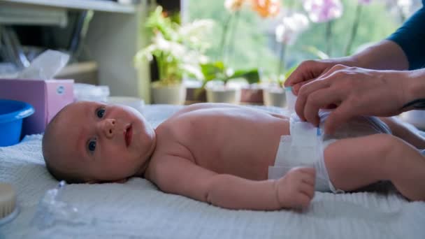 Mutter wechselt vorsichtig die Windeln ihres Babys — Stockvideo