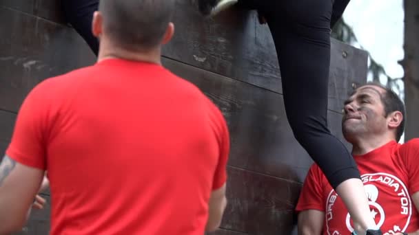 En 帮助妇女爬过高的障碍 — 图库视频影像