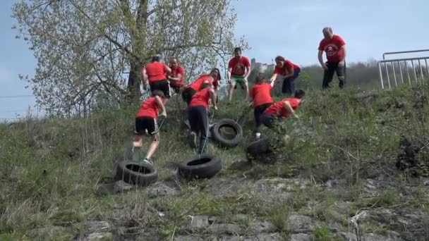 Équipe fragmenter les pneus de voiture en haut de la colline — Video