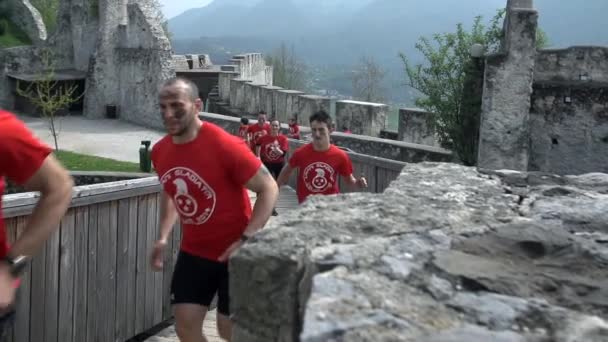 Contestants running through castle ruins — Stock Video