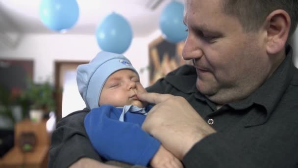 Отец нежно держит своего новорожденного ребенка — стоковое видео