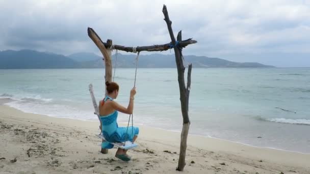 Kvinnan svängande på idylliska seaside swing — Stockvideo