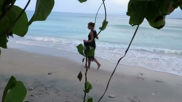 Frau geht am Meer entlang — Stockvideo