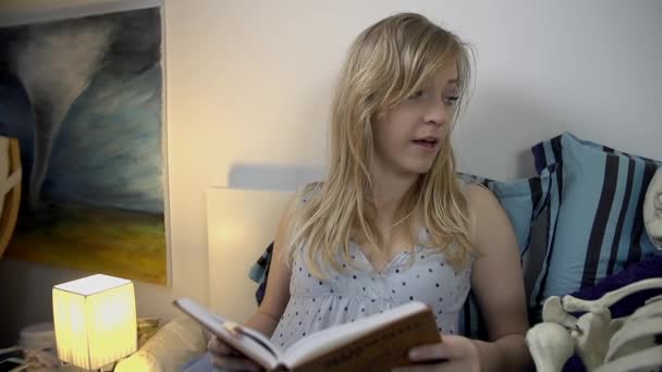 Женщина лежит со скелетом и читает — стоковое видео