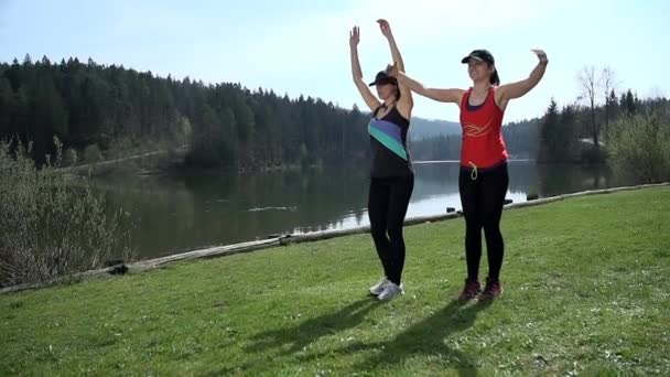 Mujeres atractivas calentando y ejercitando — Vídeo de stock