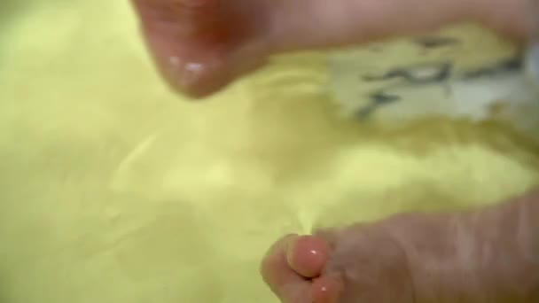 Baby 's feet in the bath — стоковое видео