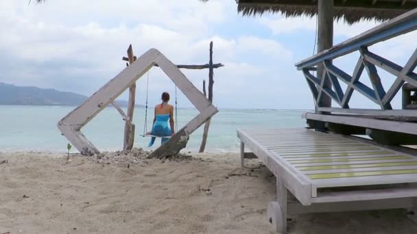 Woman swinging on idyllic seaside swing — Stock Video