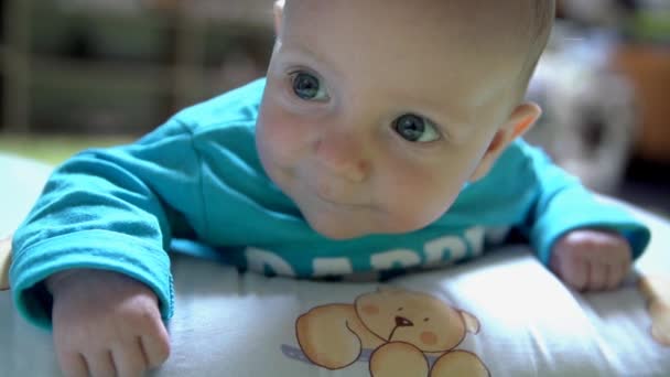 Bambino sorridente onestamente sdraiato sul pavimento — Video Stock