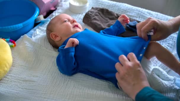 Bebé siendo vestido y nutrido por su madre — Vídeos de Stock
