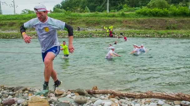 Equipe de pessoas correndo e cruzando a água — Vídeo de Stock