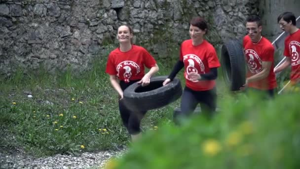Спортивная команда бегает и собирает шины — стоковое видео