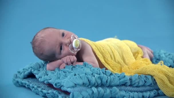 Мальчик лежит на синем одеяле — стоковое видео