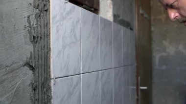 İşçi fayans üzerinden özel tutkal kalıntılarını temizler