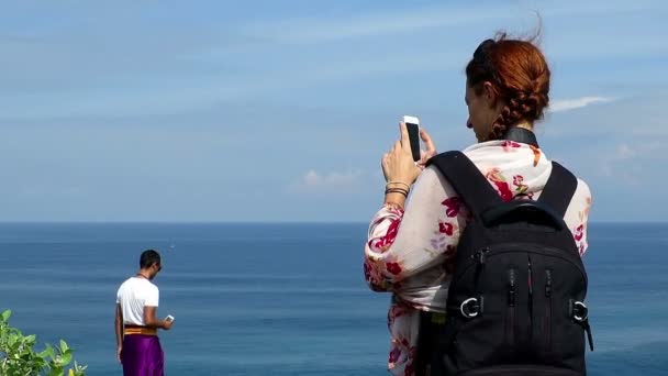 Meisje met rugzak en een man die foto's met hun telefoons — Stockvideo