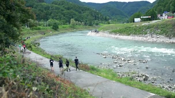 Pessoas que correm junto ao rio — Vídeo de Stock