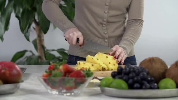 Handen met mes snijden van ananas — Stockvideo