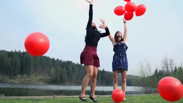 Mujeres jóvenes con globos corriendo — Vídeo de stock