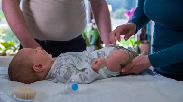 Mor och far ändrar kläder baby pojkar — Stockvideo