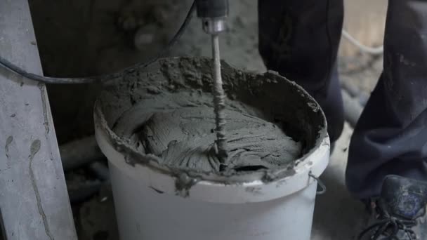 Man is mixing concrete glue with special drill — Stock Video