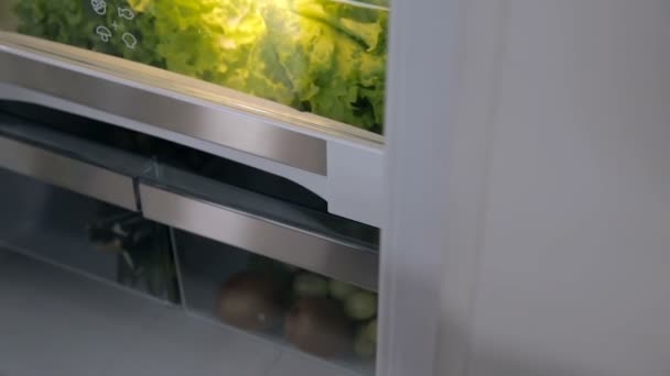 Женщина достает салат из холодильника — стоковое видео