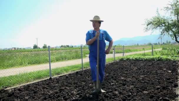 Κηπουρός που στέκεται πάνω σε ένα έδαφος έδαφος. — Αρχείο Βίντεο