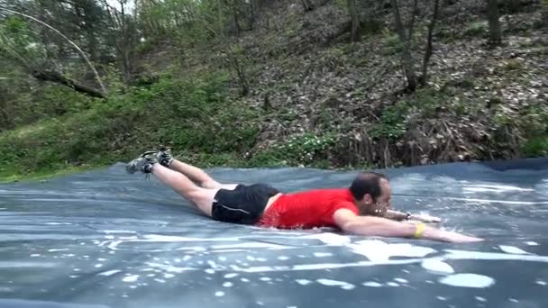 Mann gleitet durch Wasserrutsche — Stockvideo