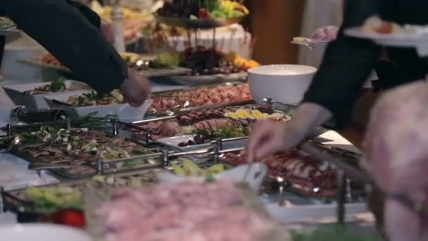 Man put food on a plate from catering — Stock Video