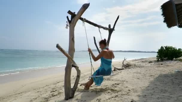 Kvinnan svängande på seaside swing — Stockvideo