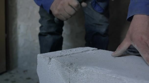 Homem está batendo tijolo sólido com martelo — Vídeo de Stock