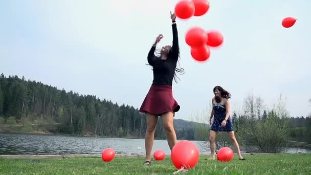 Unga kvinnor med ballonger kör — Stockvideo
