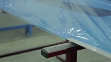 Kişi daha küçük plastik folyo parçası keser