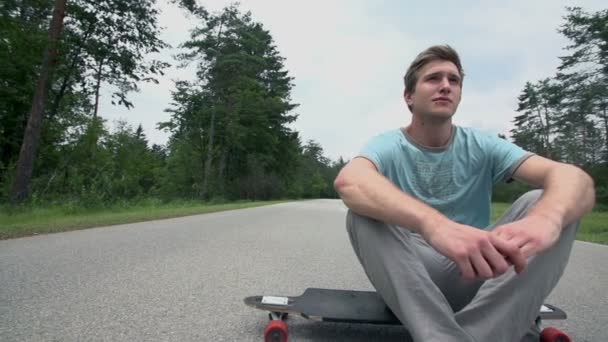 Patinador sentado en longboard — Vídeos de Stock