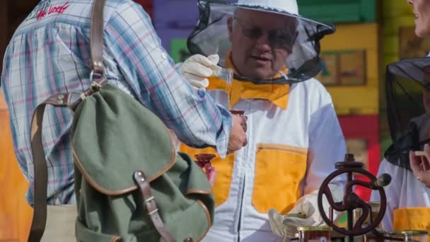 Bee keeper geeft de honing aan het echtpaar — Stockvideo