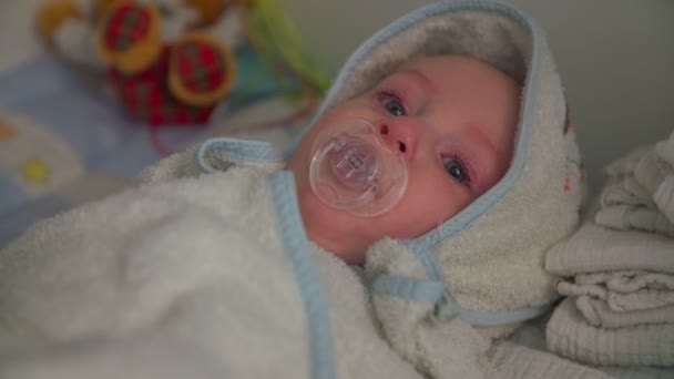 Niño acostado envuelto en una toalla después del baño — Vídeo de stock