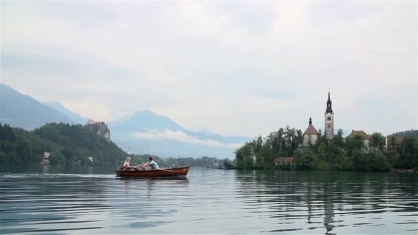 Couple flottant dans un bateau sur le lac — Video