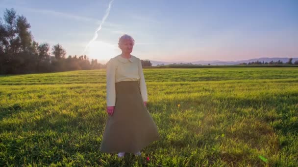 Alte Seniorin steht auf einem Feld — Stockvideo