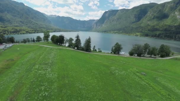 Campo de hierba cerca del lago — Vídeos de Stock