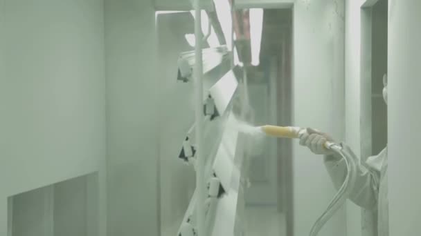 Werknemers spray plastic stukken met witte kleur — Stockvideo