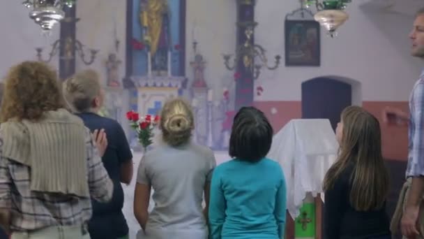 Пара с детьми, приходящими в церковь, чтобы найти следующую подсказку — стоковое видео
