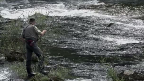 Pescador em equipamento completo stand on rock — Vídeo de Stock