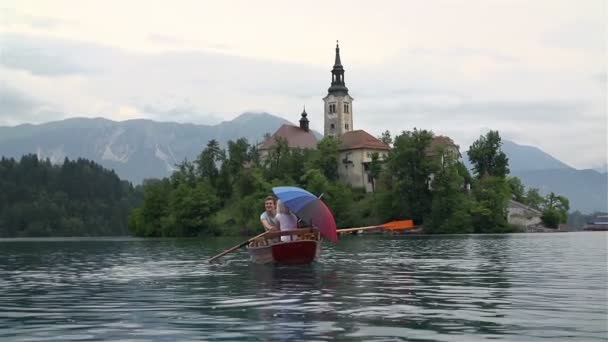 Couple flottant dans un bateau sur le lac — Video