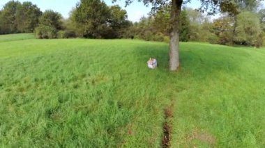 Bir ağacın altında küçük çocuk ile aile