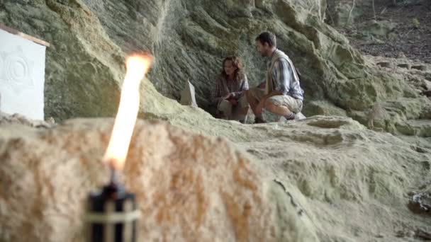 Pareja mirando el fósil frente a la cueva — Vídeos de Stock